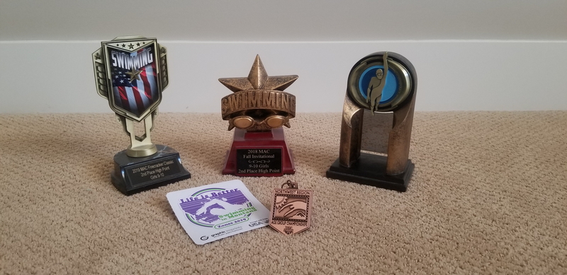 Three swimming trophies with one swimming medal